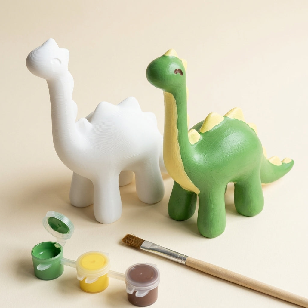Paint-your-own 3D printed dinosaur kit: blank white figure next to painted green example with paint pots and brush