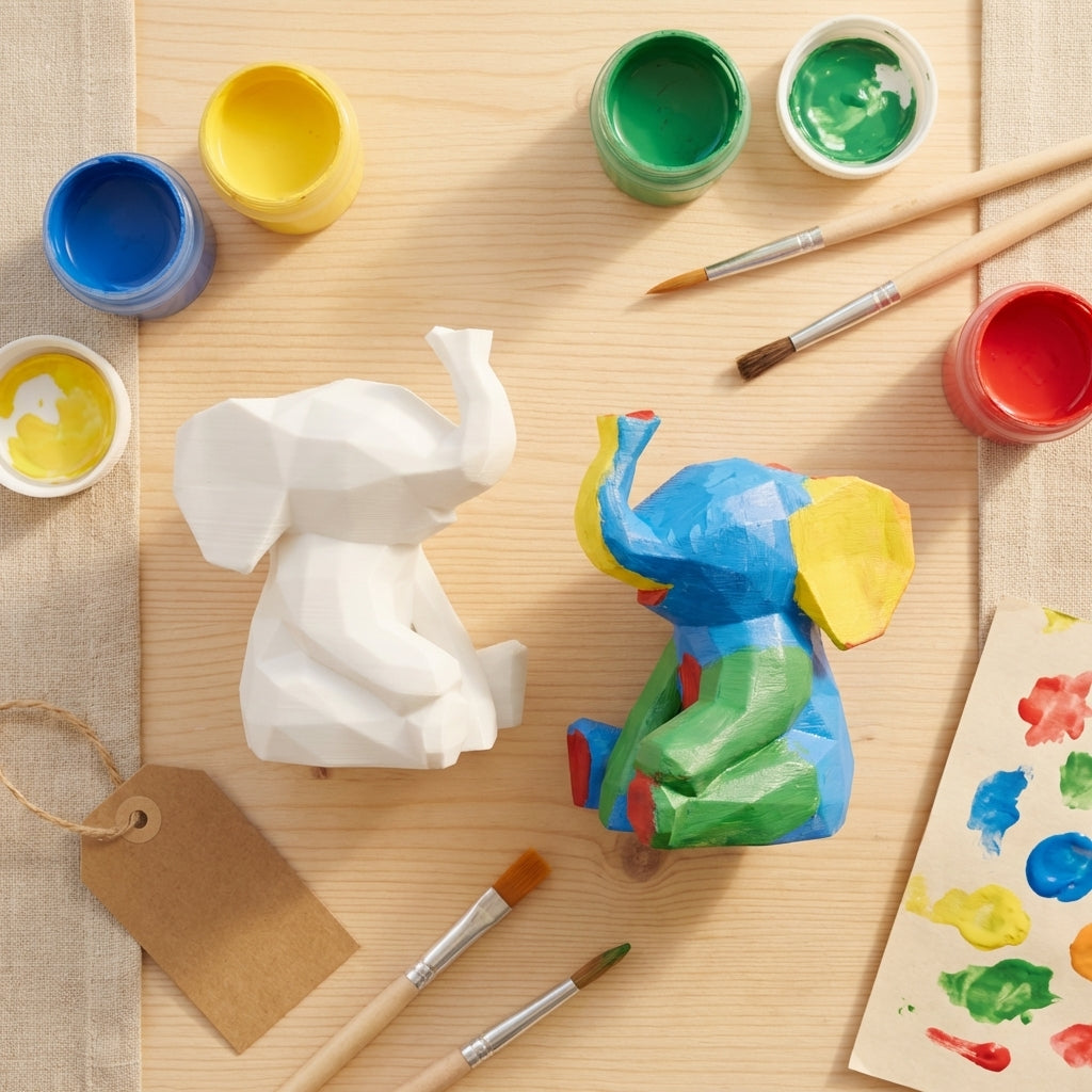 Flat-lay elephant paint kit with figurines, paint pots and brushes on wood